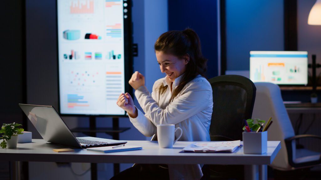 excited woman feel ecstatic reading great online news laptop working overtime start up company office happy employee using modern technology network wireless studying writing searching