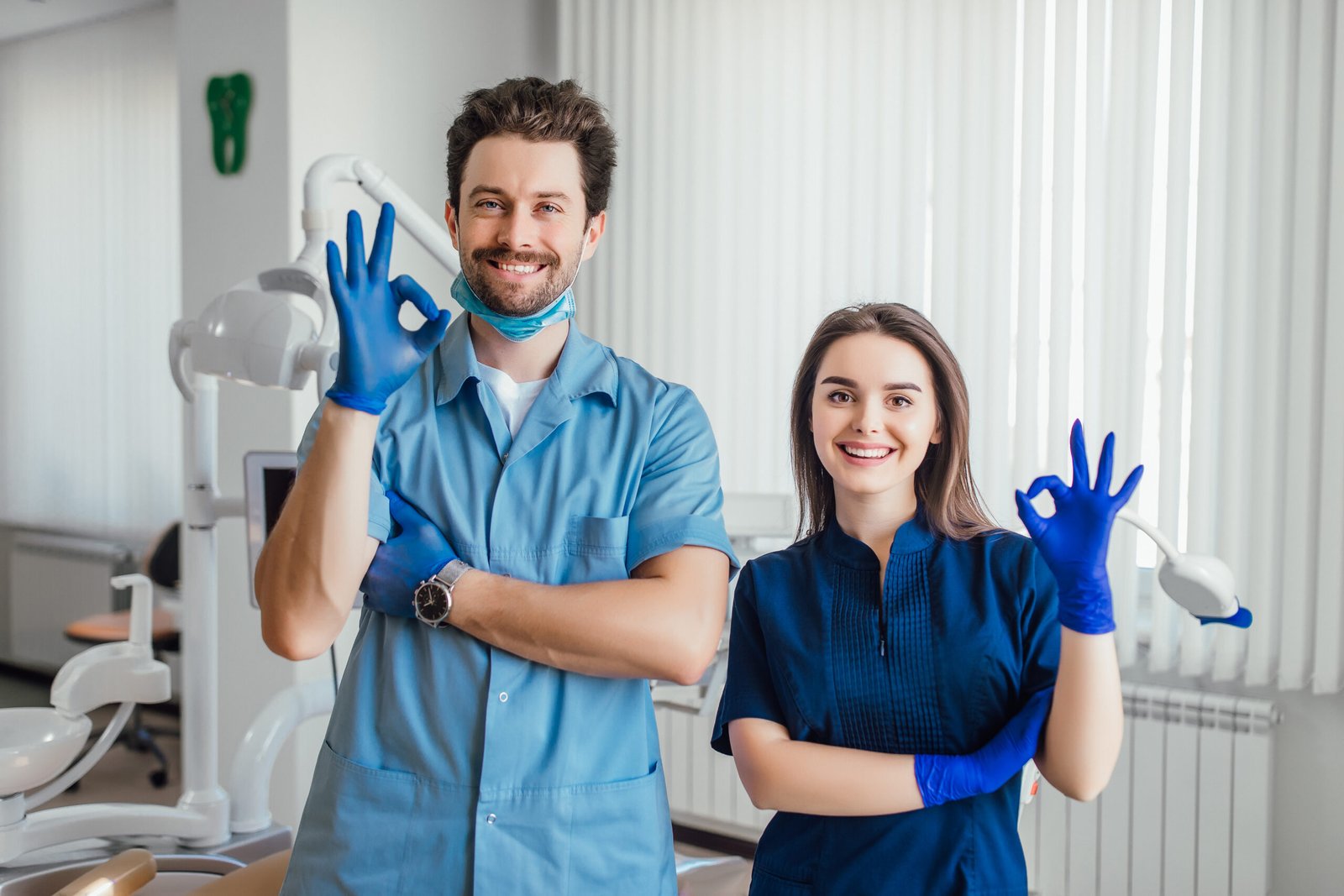 photo smiling dentist standing with arms crossed with her colleague showing okay sign scaled